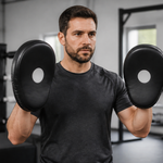 Training partner holding boxing focus mitts in a stable beginner stance
