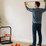 Family measuring a clear indoor wall area before setting up a mini basketball hoop