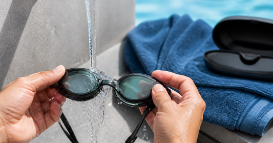 Swim goggles being gently rinsed with clean cool water after a pool session