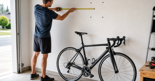Person measuring wall and bicycle clearances before installing a swivel wall-mounted bike rack in a garage