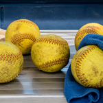 Weighted softballs being wiped and inspected after practice