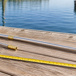 Retractable fishing gaff pole and compatible hook arranged on a dock for fit comparison