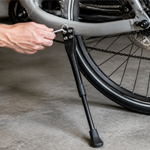 Loose bicycle kickstand being checked with a hex key