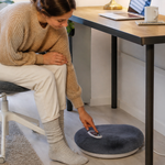 Electric foot warmer positioned on a clear dry floor beneath a tidy home office desk