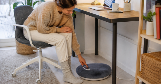 Electric foot warmer positioned on a clear dry floor beneath a tidy home office desk