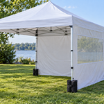 Pop-up canopy with sidewall and sandbags on a lawn